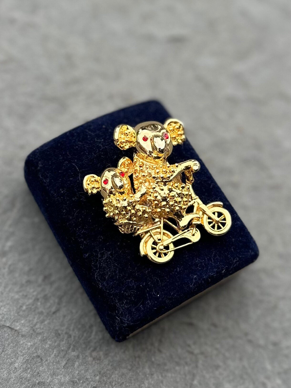 Vintage Gold Tone Koala Bear and Cub with Red Rhinestone Eyes Riding a Bike Brooch Pin