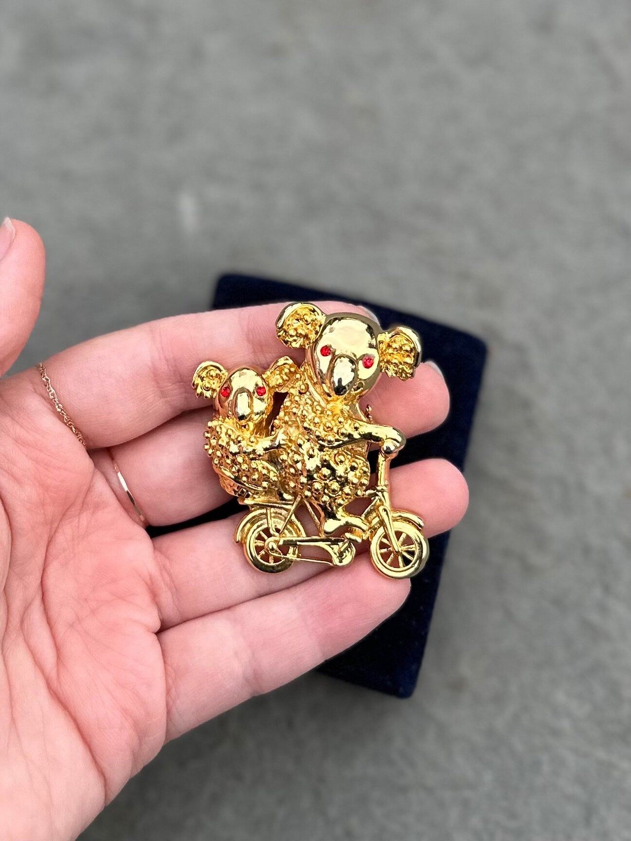 Vintage Gold Tone Koala Bear and Cub with Red Rhinestone Eyes Riding a Bike Brooch Pin